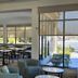 Hilton Garden Inn Dallas Lewisville dining area with tables and large windows facing the outdoor pool