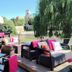 Hotel Icon Győr patio with wicker seating, pink cushions and a view of greenery and a tower