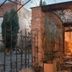 Hotel City Pisek in Písek: courtyard patio with arched iron gate, brick wall, tables and glass entry