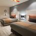 Real Inn Perinorte in Tlalnepantla guest room with two beds, desk, wall-mounted TV and modern seating area