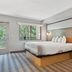 AmericInn by Wyndham Wisconsin Dells room with king bed, wood accent wall and balcony door