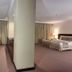 Herald Suites Solana in Makati guest room with sofa, desk, bed, and floor-to-ceiling curtains