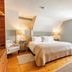 The Woodbridge Inn, Woodstock guest room with king bed, armchair, hardwood floors and window AC