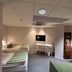 Hotell Garvaren in Ljungby, room with two single beds, desk, wall-mounted TV and carpeted floor