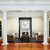 Inn at Carnall Hall in Fayetteville lobby with fireplace, seating area, white columns and built-in shelves