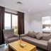 Plaza Athenee Hotel Kuwait City living room with sofa, armchair and city view through window