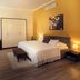 City Residence Apartment Hotel, Košice: spacious room with bed, seating area, wardrobe and yellow accent wall