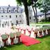 Wedding setup on lawn at Hotel Zamek Lubliniec in Lubliniec, with white chairs and red aisle runner