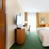 Apart-Hotel Halle in Halle: bright hotel room with two beds, TV, desk, and window