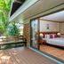Comsaed River Kwai Resort in Kanchanaburi, balcony deck beside a sliding glass door and tropical greenery