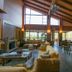 Vitina House in Vytina: rustic lounge with fireplace, high wood ceiling, bar seating and large windows