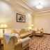 Guoyi Hotel Beijing guest room with sofa, armchair, TV and patterned carpet