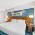 Comfort Inn & Suites Berea guest room with king bed, sofa, and bedside lamps in Berea.