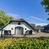 Fletcher Hotel-Restaurant De Klepperman in Hoevelaken with white barn-style buildings and a courtyard