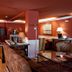 Hotel Fraga do Eume in Capela lobby lounge with bar seating, sofas, and warm red walls
