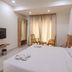 Hotel G Shy, Bhopal: simple guest room with king bed, wall-mounted TV, and seating by window