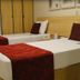 Bourbon Vitoria Residence Hotel guest room in Vitória with two twin beds and red bed runners