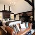 The White Swan Hotel in Stratford-upon-Avon guest room with a leather sofa and four-poster bed