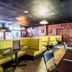 Econo Lodge Ormond Beach North - Daytona restaurant dining area with yellow booths and tables in Ormond Beach