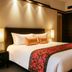 Millennium Hotel Sirih Jakarta guest room with king bed, warm lighting and mirrored wardrobe in Jakarta