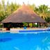 The Kairaba Beach Hotel in Serrekunda with a bright blue pool and thatched-roof poolside bar