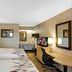 Red Roof Inn Asheville - Biltmore West guest room with two beds, desk, TV and bathroom vanity