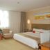 Gloria Grand Hotel Nanchang guest room with king bed, armchairs and bright window