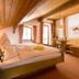 Landhotel Binderhäusl Garni in Inzell: cozy wood-paneled guest room with bed, seating nook, and windows