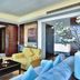 Parkyard Hotel Jiaxing in Jiaxing living room with yellow sofas, blue chairs, TV and wood-paneled walls