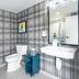 Gravity Haus Steamboat bathroom with plaid wallpaper, toilet, sink, mirror and shower visible in Steamboat Springs