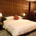 Foshan Jincheng Hotel guest room with king bed, chandelier lighting, and tufted wall panels in Foshan