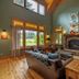 Copper Creek Inn, Cabins and Lodge in Ashford: rustic lodge living room with stone fireplace and forest views