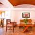 Hotel Maria de Lourdes lobby seating area in Cancún with wooden chairs and table