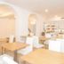 Hotel Playas de Paguera in Peguera dining room with light wood tables, white chairs and arched openings
