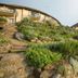 The Cavern in Bonjaneni with terraced gardens, stone steps, and hillside lodge exterior