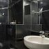 Neuilly Park Hotel bathroom in Neuilly-sur-Seine with black tile shower and white sink