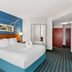 Comfort Inn & Suites Berea guest room with king bed, blue accent wall, bedside lamp and bathroom view