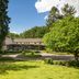 Bilderberg Hotel 't Speulderbos in Garderen surrounded by lush gardens and trees under a blue sky