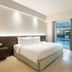 Harris Hotel & Residences Sunset Road Kuta guest room with king bed and pool view through sliding doors