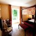 Hostellerie Les Hauts De Sainte Maure bedroom with four-poster bed and open door to garden