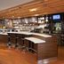 Courtyard by Marriott Fayetteville bar with curved counter, stools, TV screens and drink fridge