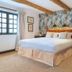 Cotswold Plough Hotel & Restaurant in Bampton bedroom with floral wallpaper, exposed beams and a king bed