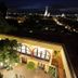 Casa Mia Suites in San Miguel de Allende at night, with lit arches and city lights beyond