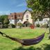 Manoir de la Poterie & Spa in Honfleur with a hammock on the lawn before a half-timbered hotel