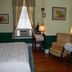 Lost Bayou Guesthouse in Galveston room with bed, desk, armchair, lamps, and window air conditioner