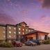 Best Western Plus St. Albert exterior at dusk with parked cars and a colorful sunset sky in Saint Albert
