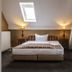 Hotel Ulmenhof & Spa, Bredstedt: attic bedroom with double bed, skylight, bedside lamps and sloped ceiling