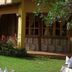 Hotel Mediterraneo Plaza in San Salvador exterior with garden, yellow facade, and wooden doors