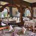 Landhotel Binderhäusl Garni dining room in Inzell with set tables, wood beams, and arched windows