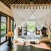 Amertha Bali Villas in Gerokgak with a canopy bed, open patio doors, and tropical garden view.